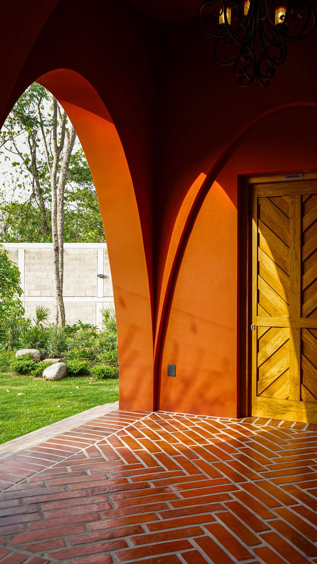 Arco terracota con puerta de madera que da al jardín