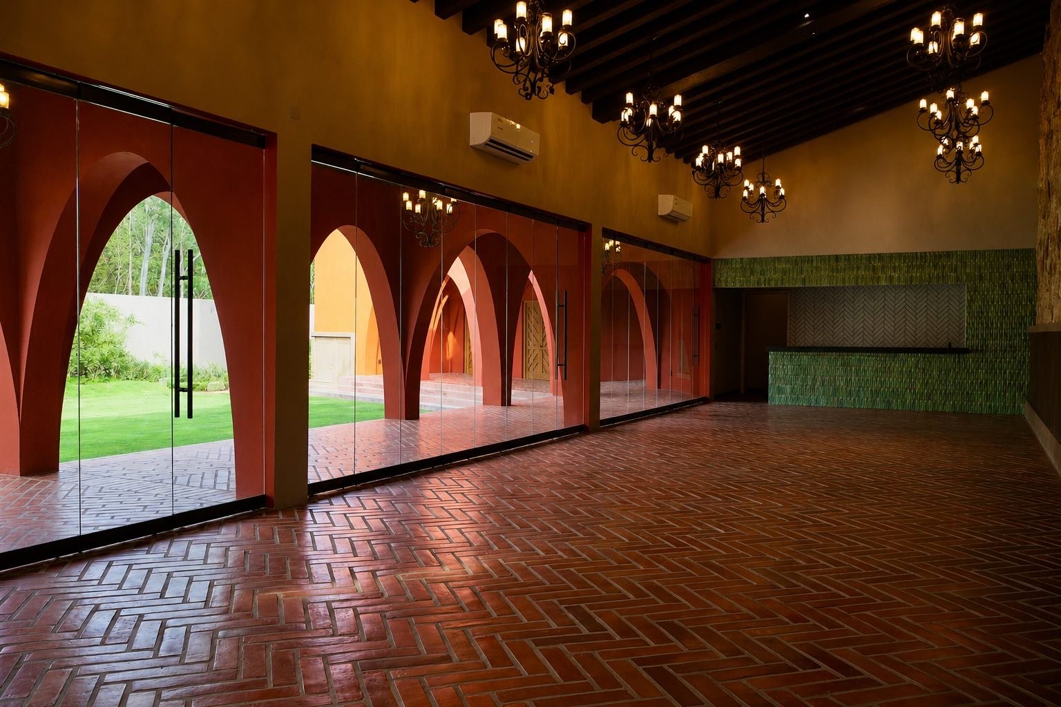 Salón climatizado con candiles, piso de barro y puertas de vidrio en arco